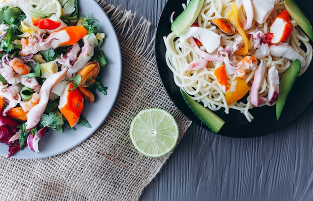 salad and pasta with seafood on  wooden background