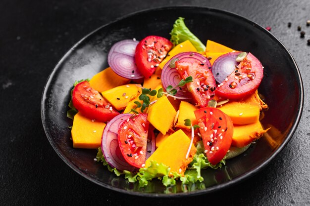 Salad pumpkin tomato mix vegetables fresh portion ready to eat meal snack on the table copy space