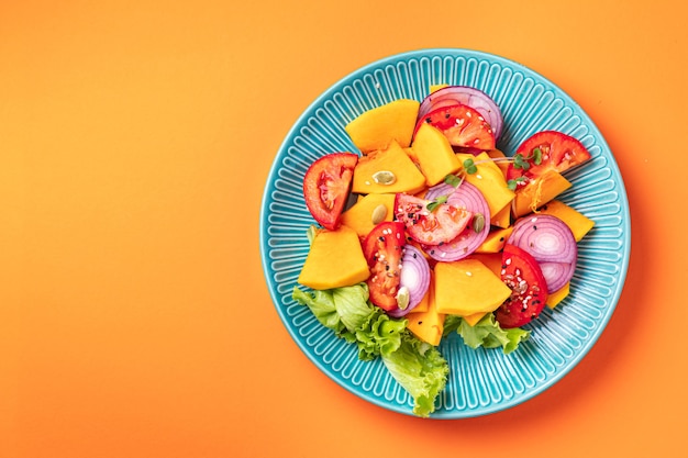 Salad pumpkin tomato mix vegetables fresh portion ready to eat meal snack on the table copy space