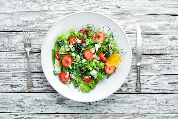 Salad Salad of arugula blue cheese strawberries and blueberries Top view