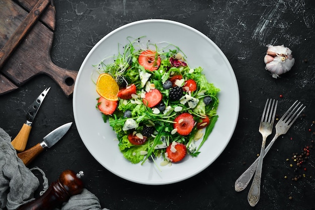 Salad Salad of arugula blue cheese strawberries and blueberries Top view