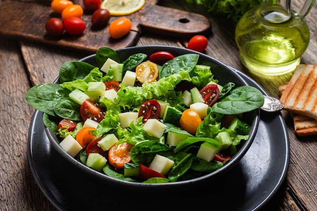 Salad of spinach cherry tomatoes and cheese in a plate