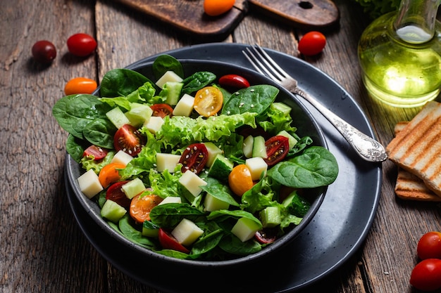 Salad of spinach cherry tomatoes and cheese in a plate