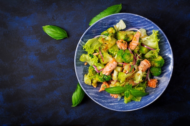 Salad of stewed fish salmon, broccoli, lettuce and dressing. Fish menu. Dietary menu. Seafood - salmon.