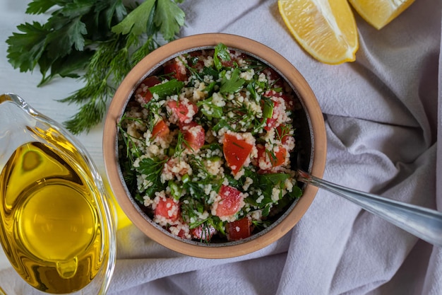Photo salad tabbouleh with couscous parsley tomato and olive oil