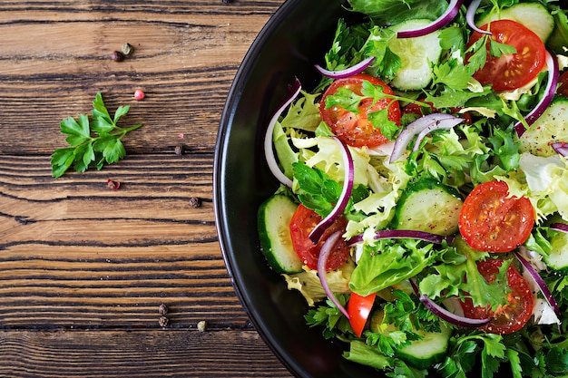 Salad tomatoes, cucumber, red onions and lettuce leaves.