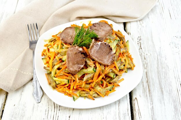 Salad of tongue and carrots with napkin on board