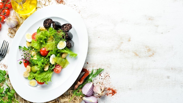 Salad of vegetables, blood sausage and mushrooms on a plate. Top view. free space for your text. Rustic style.