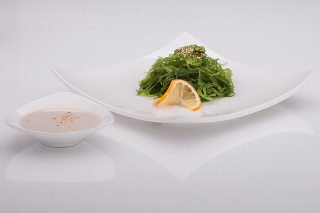 Salad in a white plate on a white background