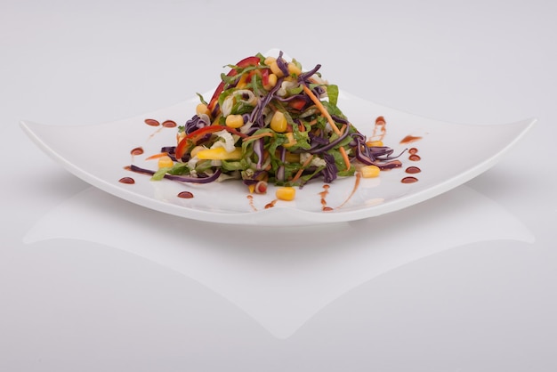 Salad in a white plate on a white background