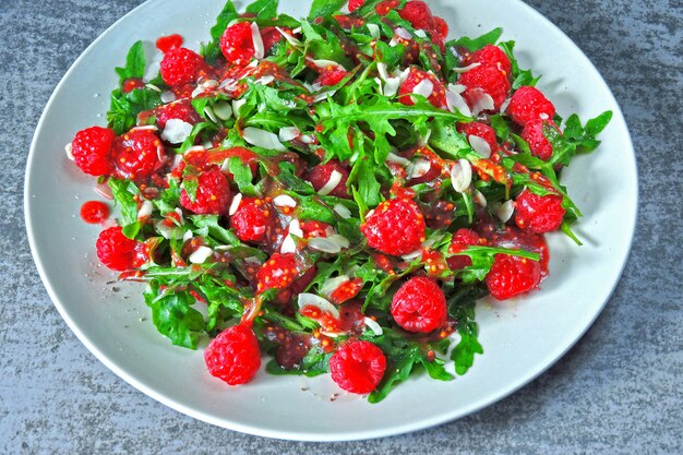 Salad with arugula-raspberry, with almond petals. Fresh and nutritious fitness salad