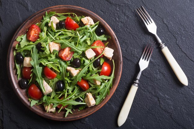 Salad with arugula tomatoes olives and chicken