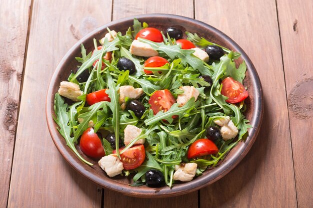 Salad with arugula tomatoes olives and chicken