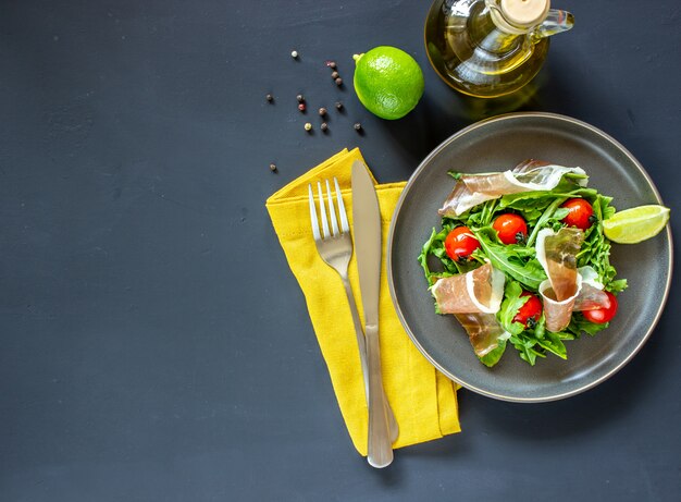 Salad with arugula, tomatoes and prosciutto.