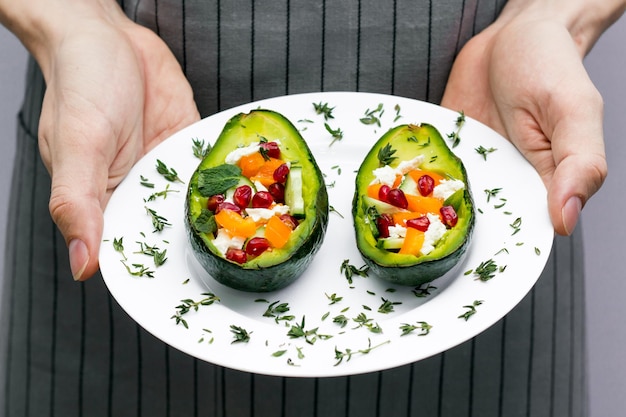 Photo salad with avocado fresh vegetables feta cheese garnets and tangerines healthy diet vegetarian food