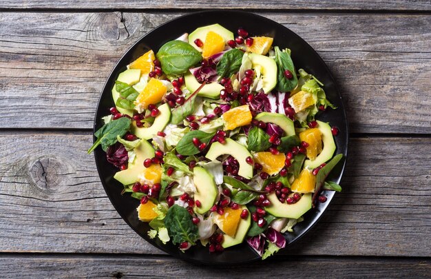 Salad with avocado orange spinach and pomegranate