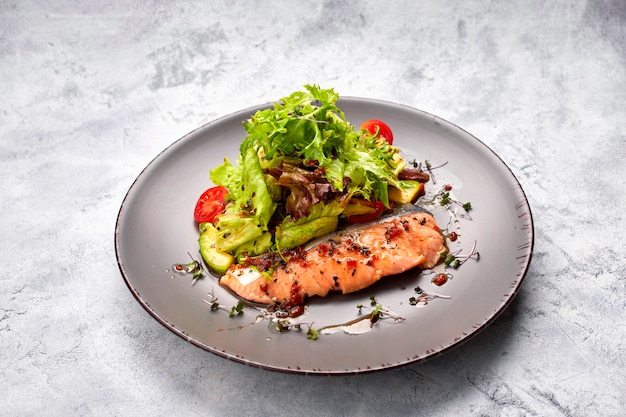 Salad with avocado and salmon, on a light background