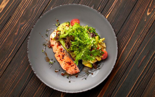 Insalata con avocado e salmone, su uno sfondo di legno