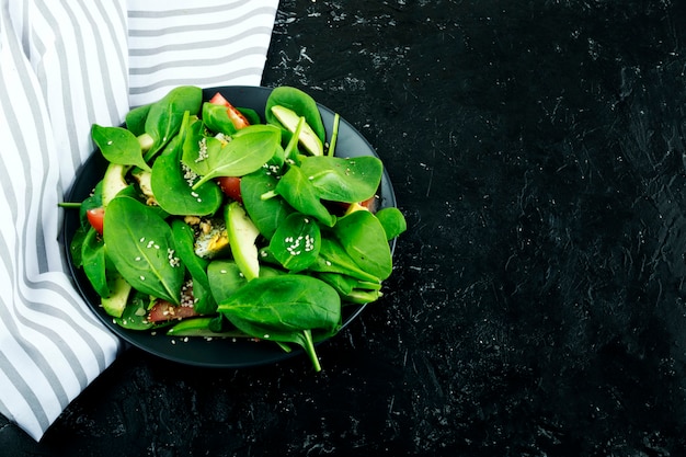 Photo salad with avocado and tomato spinach leaves. proper nutrition, healthy demand for life.