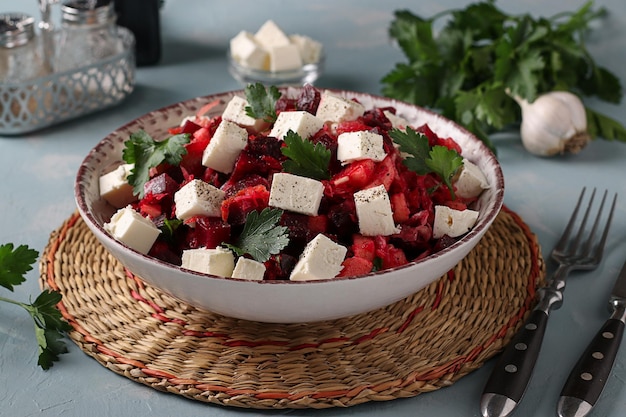 Salad with beetroot cabbage and feta cheese in a bowl on light blue background