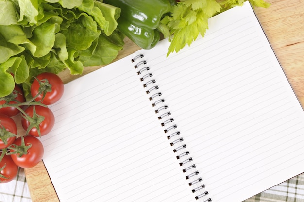 Photo salad with blank recipe book and chopping board