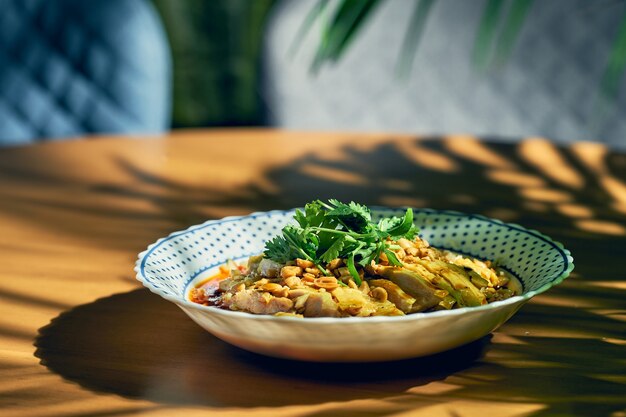 Salad with boiled chicken, cilantro, peanuts in hot soy sauce. Chinese cuisine.