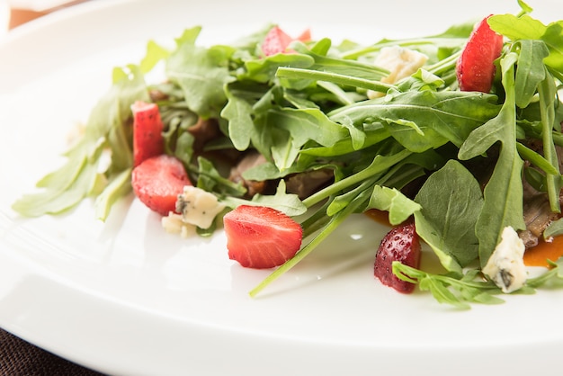 Salad with cheese Dor Blue, garnished with strawberries