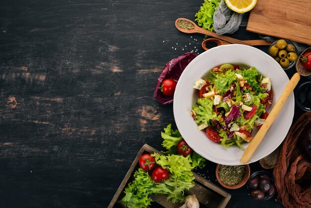 Salad with cheese nuts and fresh vegetables On a wooden background Top view Copy space for your text