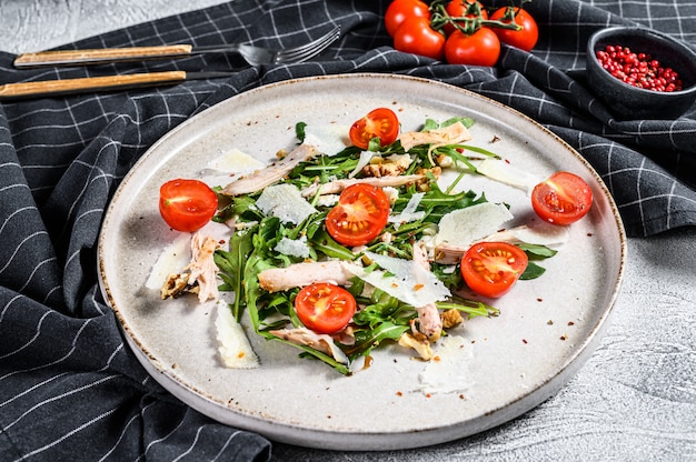 Салат с курицей, рукколой, грецкими орехами, помидорами и пармезаном. Вид сверху