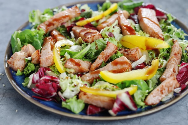 Salad with chicken chunks served on plate. Closeup