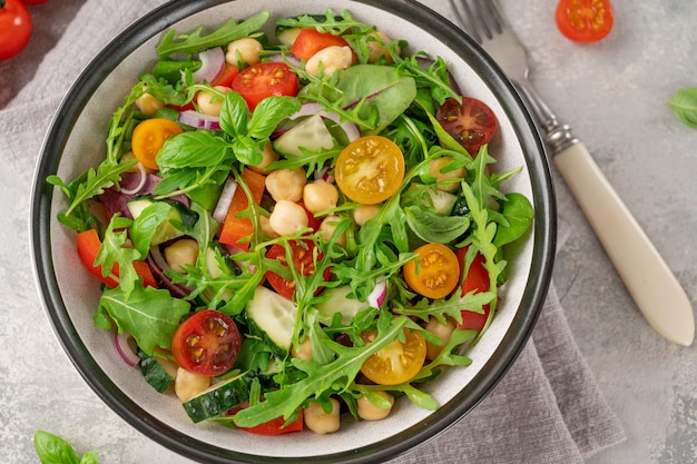 Salad with chickpeas green leaves and fresh vegetables in a bowl Healthy food Top view copy space