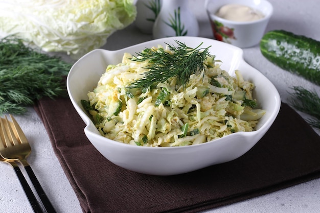 Insalata con uova di cavolo cinese, formaggio e cetriolo condita con maionese e guarnita con aneto