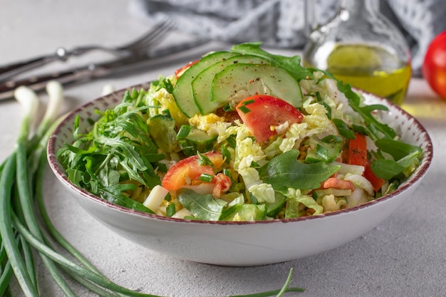 Salad with Chinese cabbage tomatoes chives eggs and cucumber dressed with olive oil Closeup