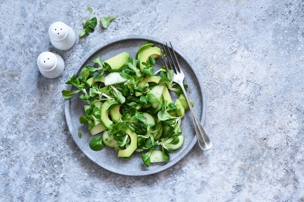 salad with cucumber and avocado on a concrete table