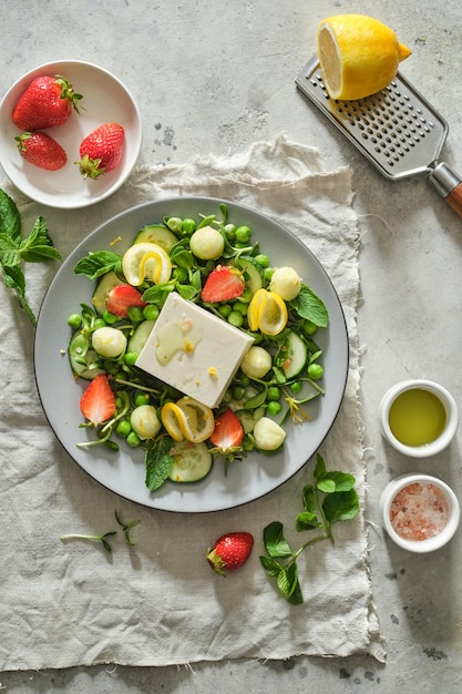 Salad with feta mint melon strawberries lemon and green peas Fresh summer salad Vegetarian salad