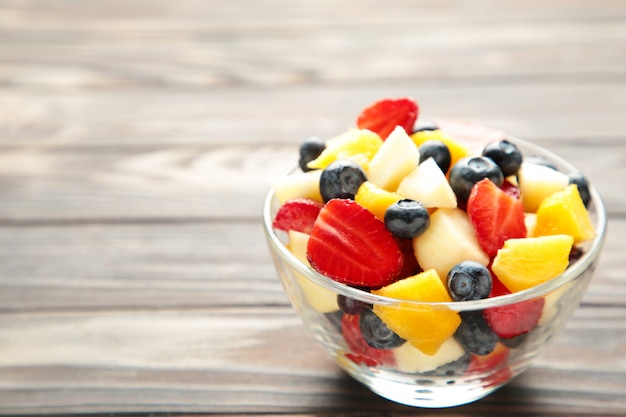 Salad with fresh fruits and berries on brown