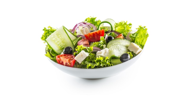 Салат из свежих овощей, оливок, помидоров, красного лука, греческого сыра, фета и оливкового масла, изолированных на белом фоне.