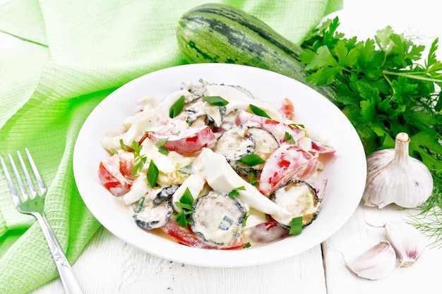 Photo salad with fried zucchini in plate on light board