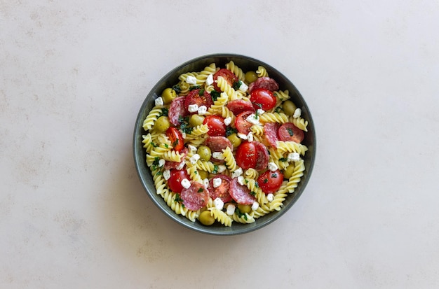 Salad with fusilli pasta sausage olives and cottage cheese Italian food