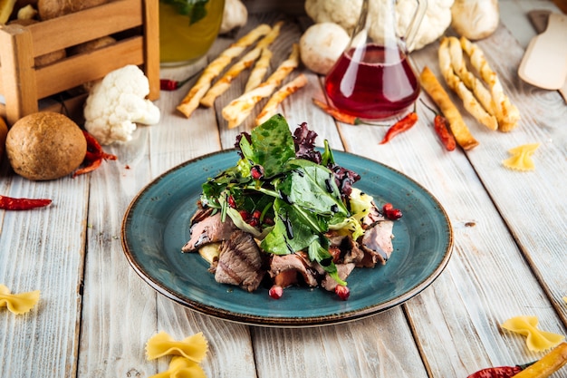 Salad with greens meat and pomegranate