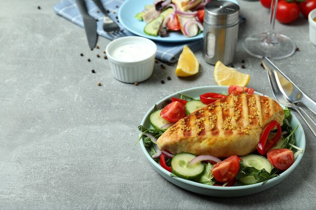 Insalata con pollo alla griglia su tavola grigia