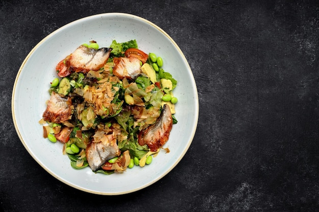 Salad with grilled eel and vegetables on a plate