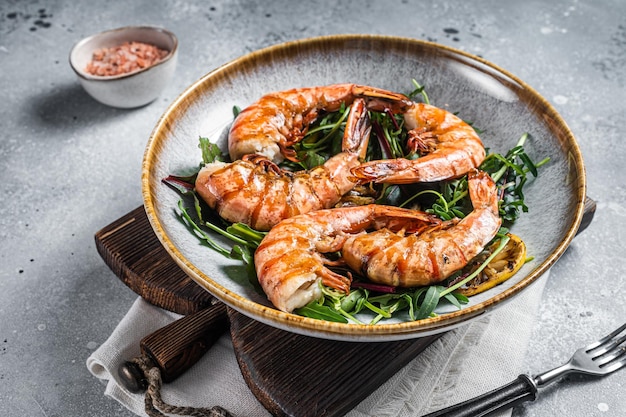 Photo salad with grilled giant shrimps prawns in plate gray background top view