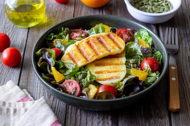 Salad with grilled halloumi cheese tomatoes orange and pumpkin seeds Healthy eating Vegetarian food Keto diet