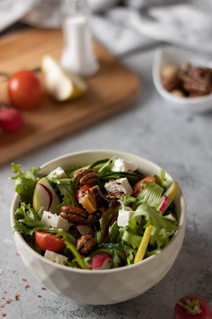 Salad with herbs and fruits on a light background closeup