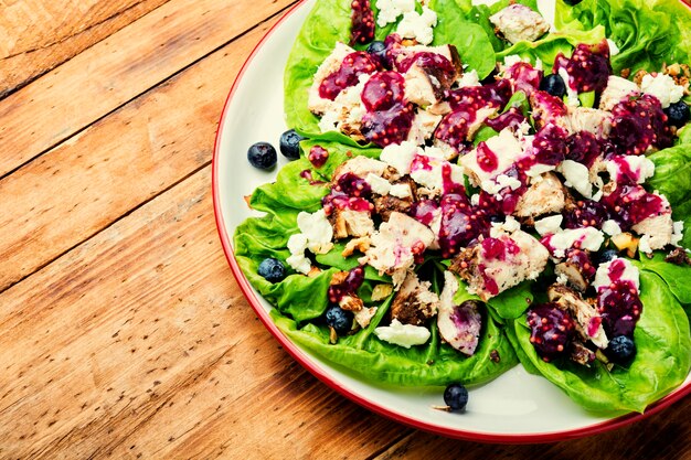 Salad with herbs, grilled chicken, nuts and blueberries.Copy space