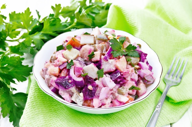 Photo salad with herring and beetroot in bowl on table