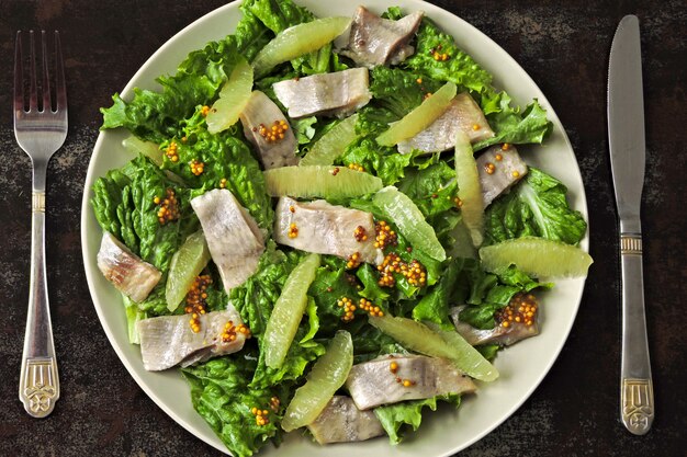 Salad with herring and lemon fillet.