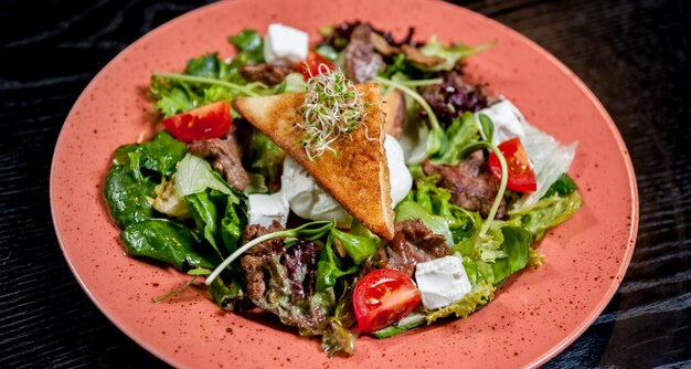 Salad with meat and vegetables on a plate.