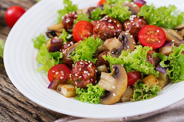 Salad with meatballs, eggplant, mushrooms and tomatoes in Asian style